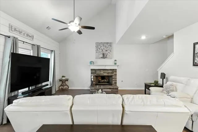 a living room with furniture a fireplace and a flat screen tv