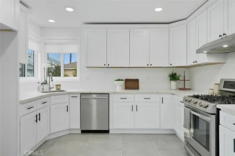 a kitchen with white cabinets and white appliances
