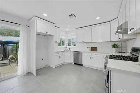 a kitchen with white cabinets and white appliances