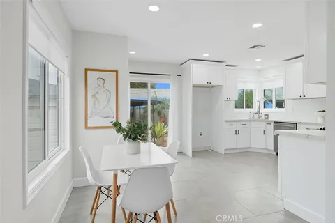 a kitchen with white cabinets and refrigerator