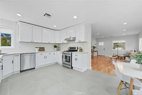 a kitchen with white cabinets and appliances