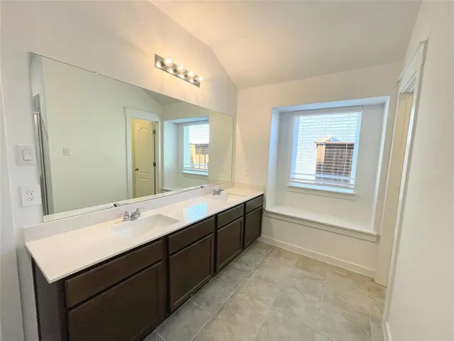a bathroom with a sink a large mirror and a bathtub