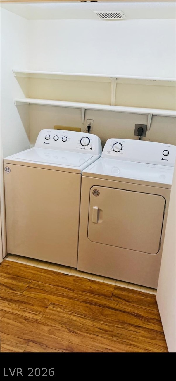 5131 South Lindell Road, Unit 205 Las Vegas, NV 89118 - Photo 19 of 22 Laundry room with laundry area, visible vents, washer and clothes dryer, and wood finished floors