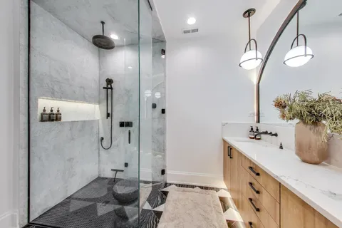 a bathroom with a granite countertop sink a toilet and shower