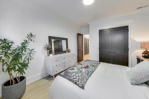 a bedroom with a large bed and a potted plant