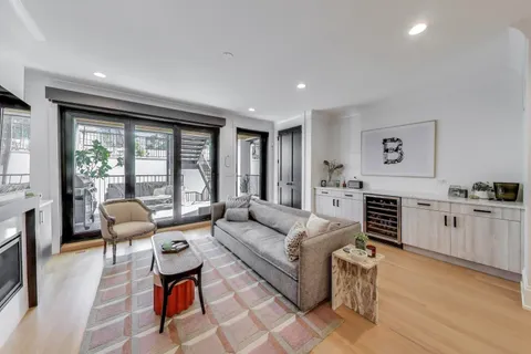 a living room with furniture large window and wooden floor