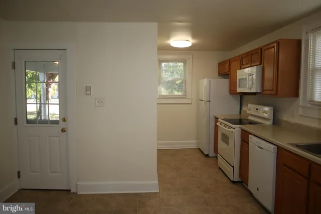 a kitchen with a refrigerator and a stove top oven