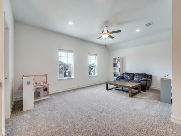 a living room with furniture and a ceiling fan