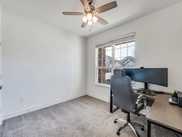 a view of a workspace with furniture and a window