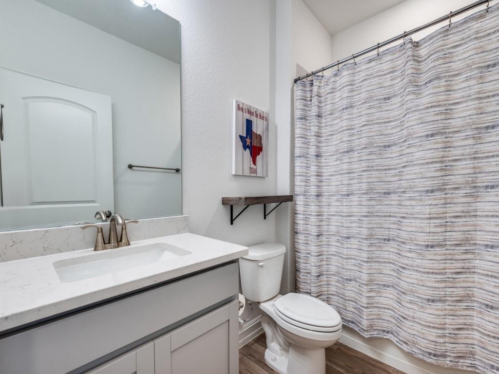4408 Minnow Cove Oak Point, TX 75068 - Photo 20 of 31 a bathroom with a toilet sink and mirror