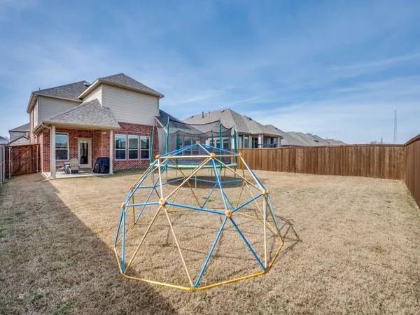 a view of a house with a yard and wooden fence