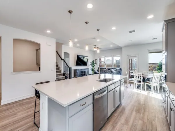 a large kitchen with kitchen island a sink table and chairs