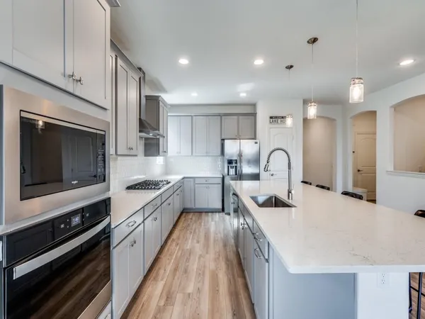 a large kitchen with stainless steel appliances and a kitchen island