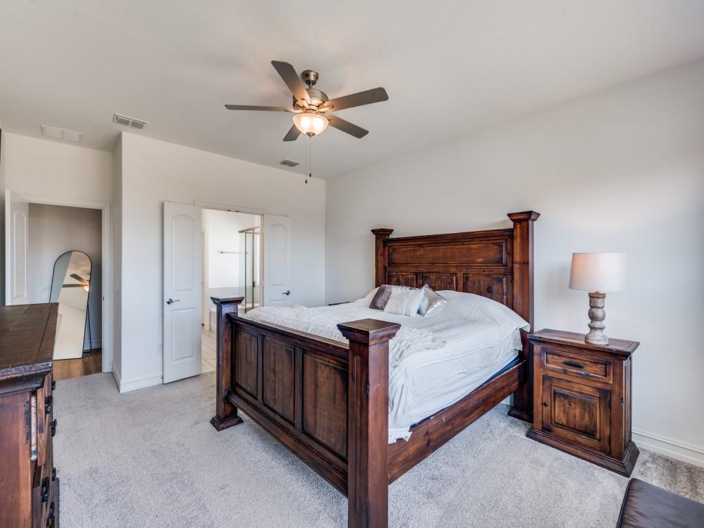 4408 Minnow Cove Oak Point, TX 75068 - Photo 10 of 31 a bedroom with a bed and a chandelier