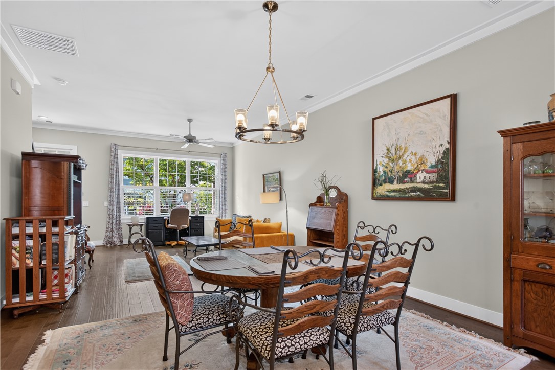 112 Tuttle Street Clemson, SC 29631 - Photo 13 of 46 An inviting dining room with crown molding features a stylish chandelier and hardwood flooring.