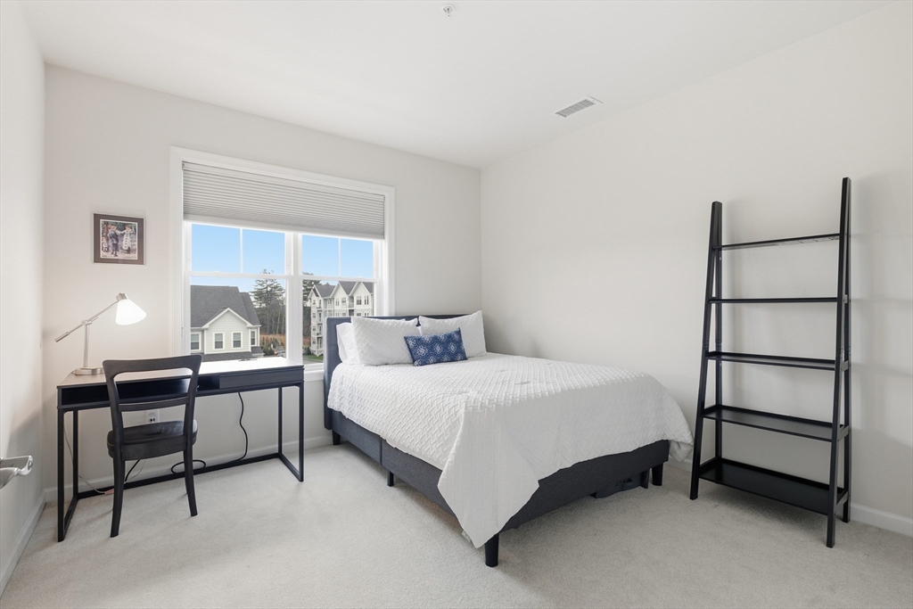 401 Emery Lane, Unit 304 Sudbury, MA 01776 - Photo 14 of 25 a bedroom with a bed table lamp and a window