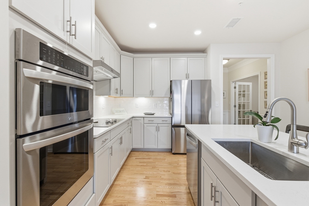 401 Emery Lane, Unit 304 Sudbury, MA 01776 - Photo 3 of 25 a kitchen with stainless steel appliances granite countertop a kitchen island a stove a sink and a refrigerator