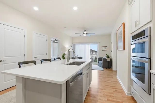 a large kitchen with a sink and stainless steel appliances