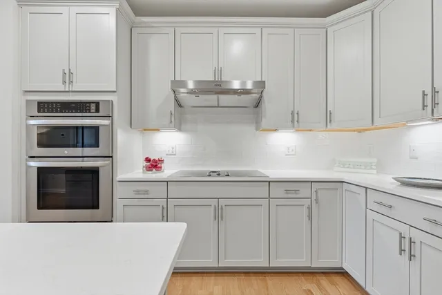 a kitchen with white cabinets and stainless steel appliances