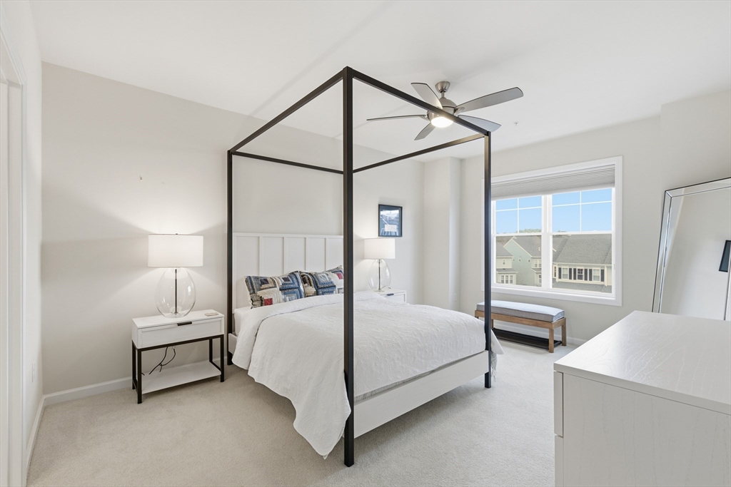 401 Emery Lane, Unit 304 Sudbury, MA 01776 - Photo 9 of 25 a bedroom with a bed and a table