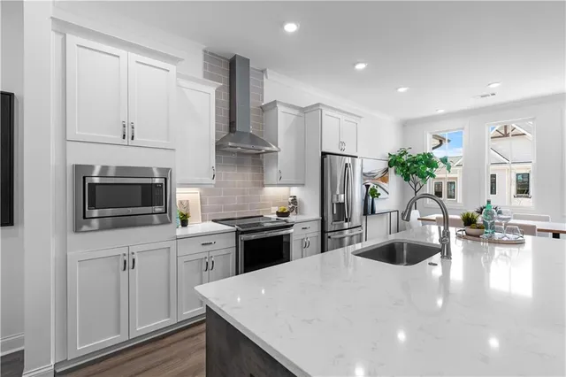 a kitchen with stainless steel appliances kitchen island granite countertop a sink dishwasher stove and refrigerator