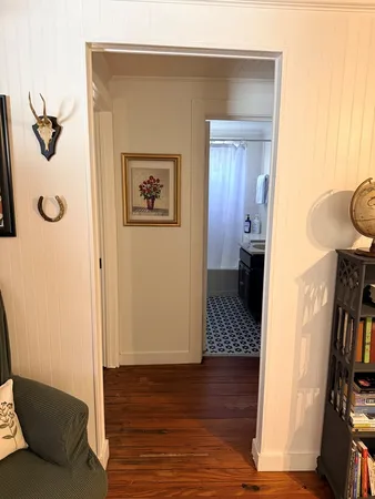 a view of a hallway with wooden floor and closet