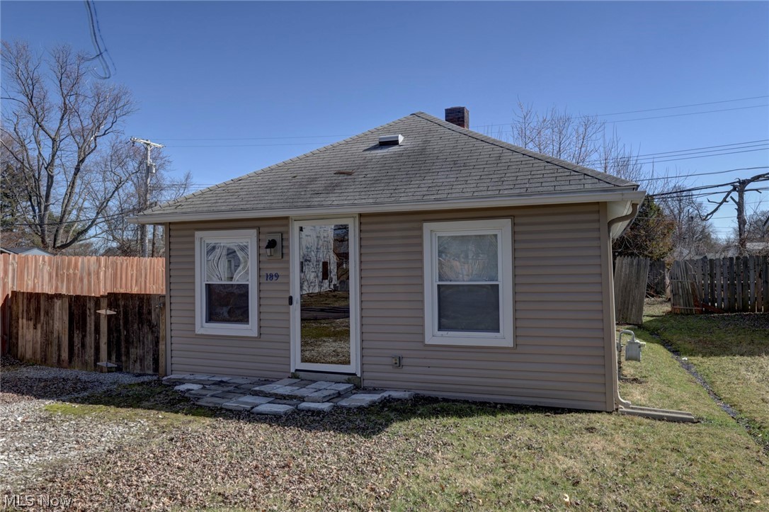 189 Harcourt Road Vermilion, OH 44089 - Photo 2 of 36 Rear view of house with a fenced backyard, roof with shingles, and a patio area