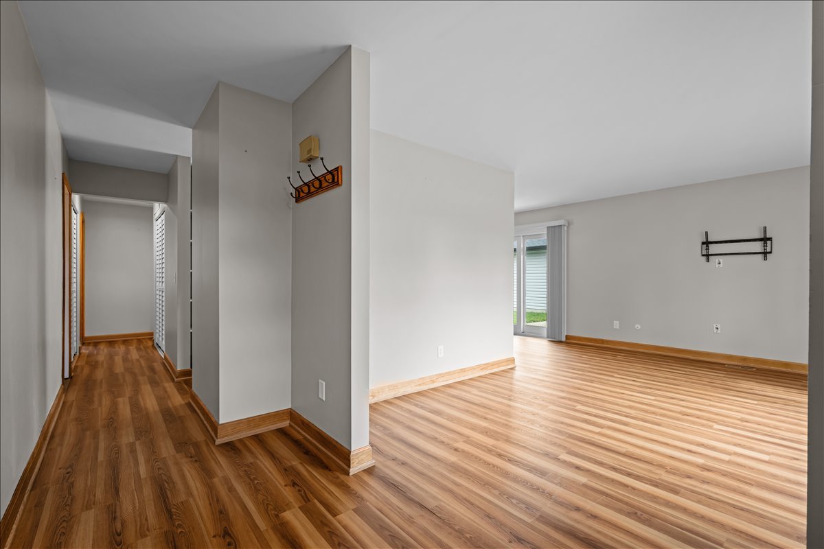 124 Heathgate Road Montgomery, IL 60538 - Photo 4 of 28 an empty room with wooden floor and a bathroom
