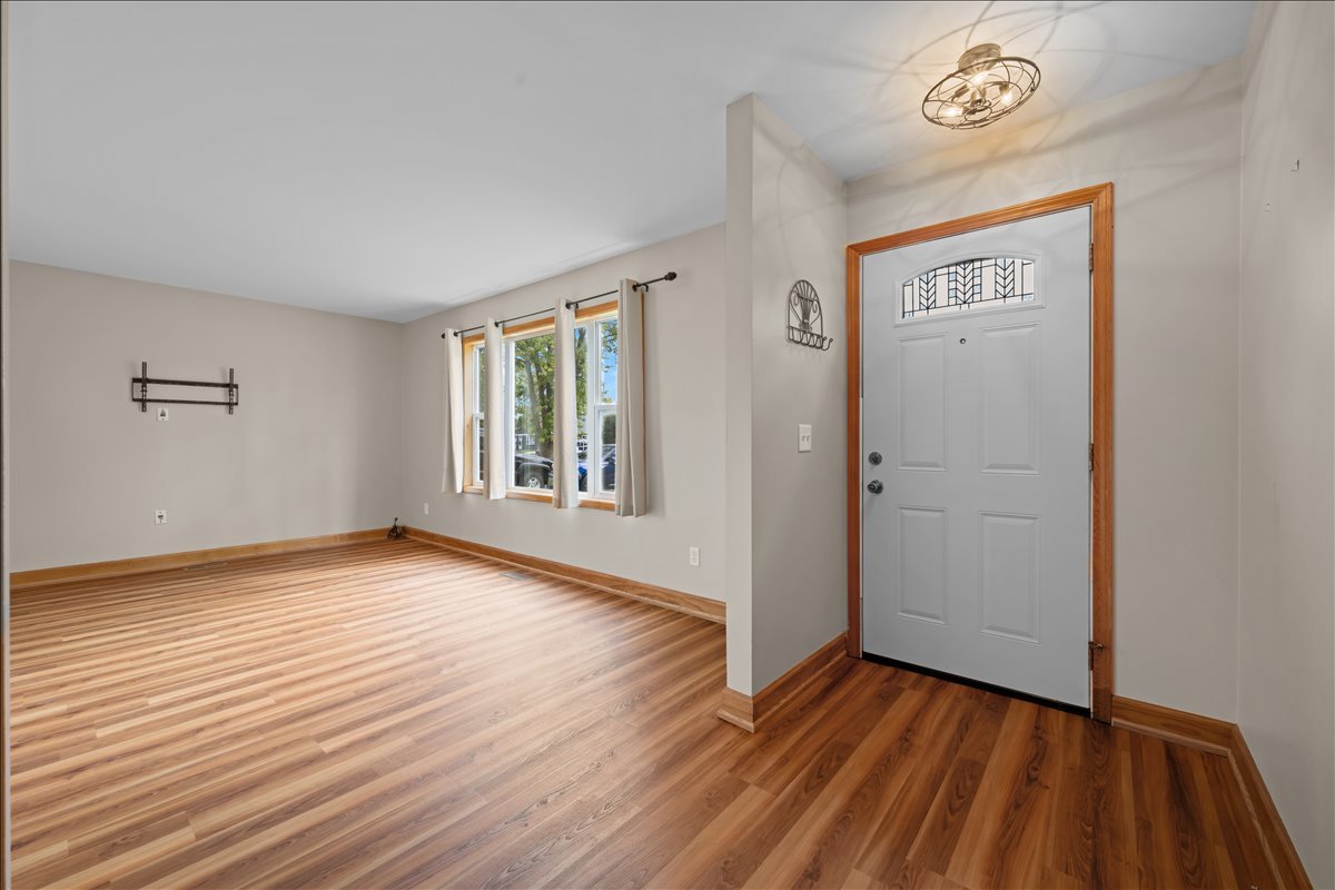 124 Heathgate Road Montgomery, IL 60538 - Photo 5 of 28 an empty room with wooden floor and windows