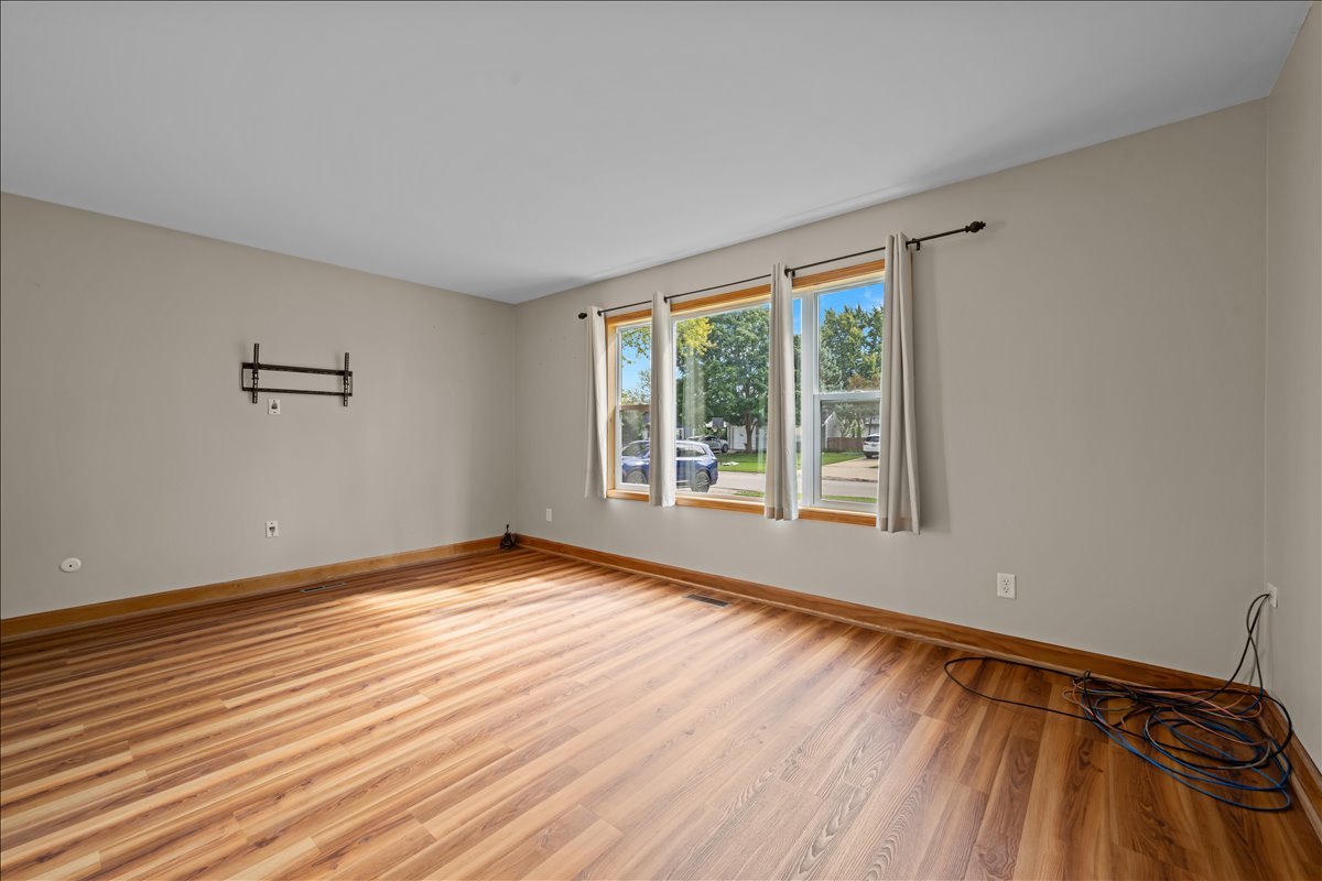 124 Heathgate Road Montgomery, IL 60538 - Photo 7 of 28 a view of an empty room with wooden floor and a window