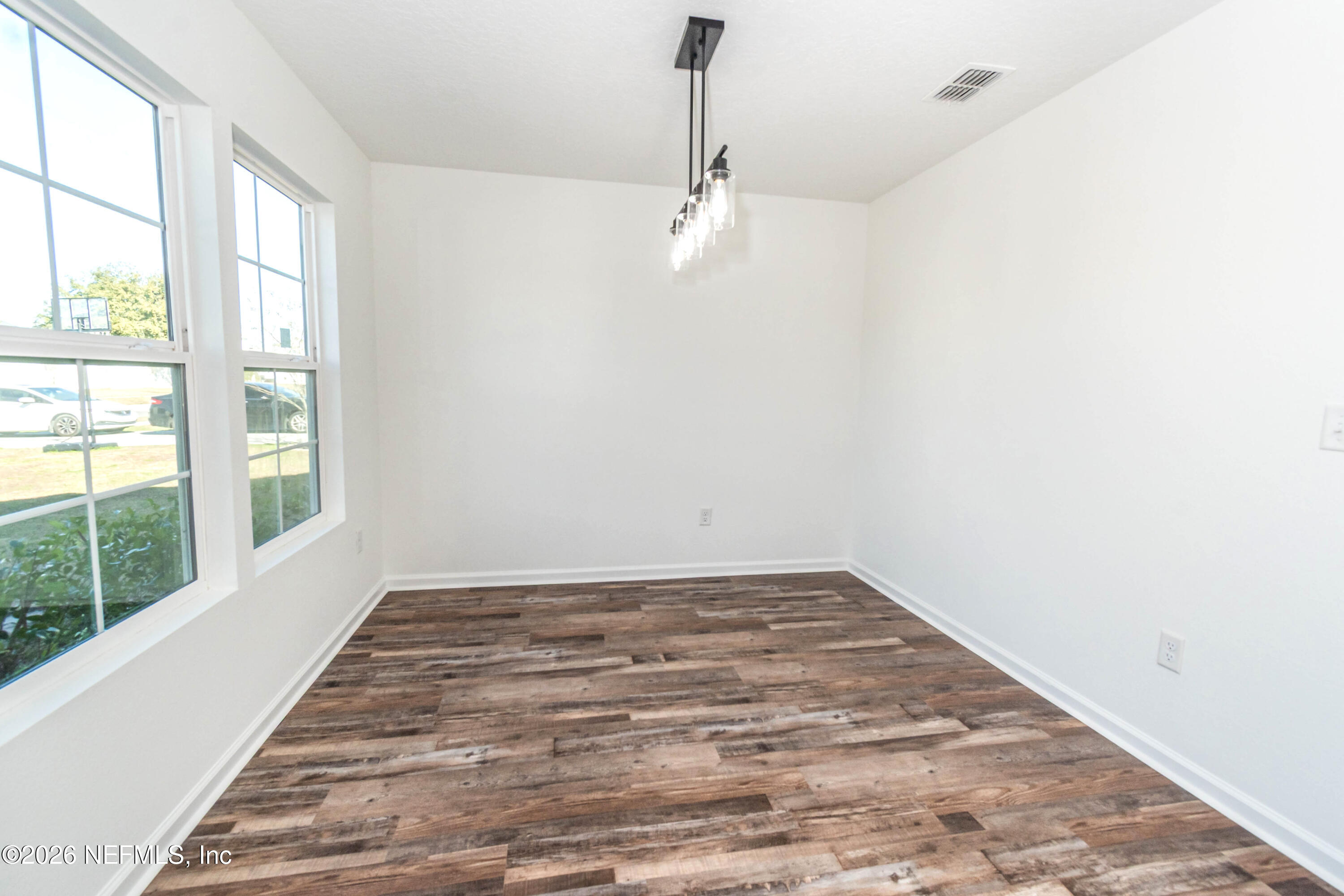 768 Constitution Place Macclenny, FL 32063 - Photo 15 of 41 an empty room with wooden floor fan and windows