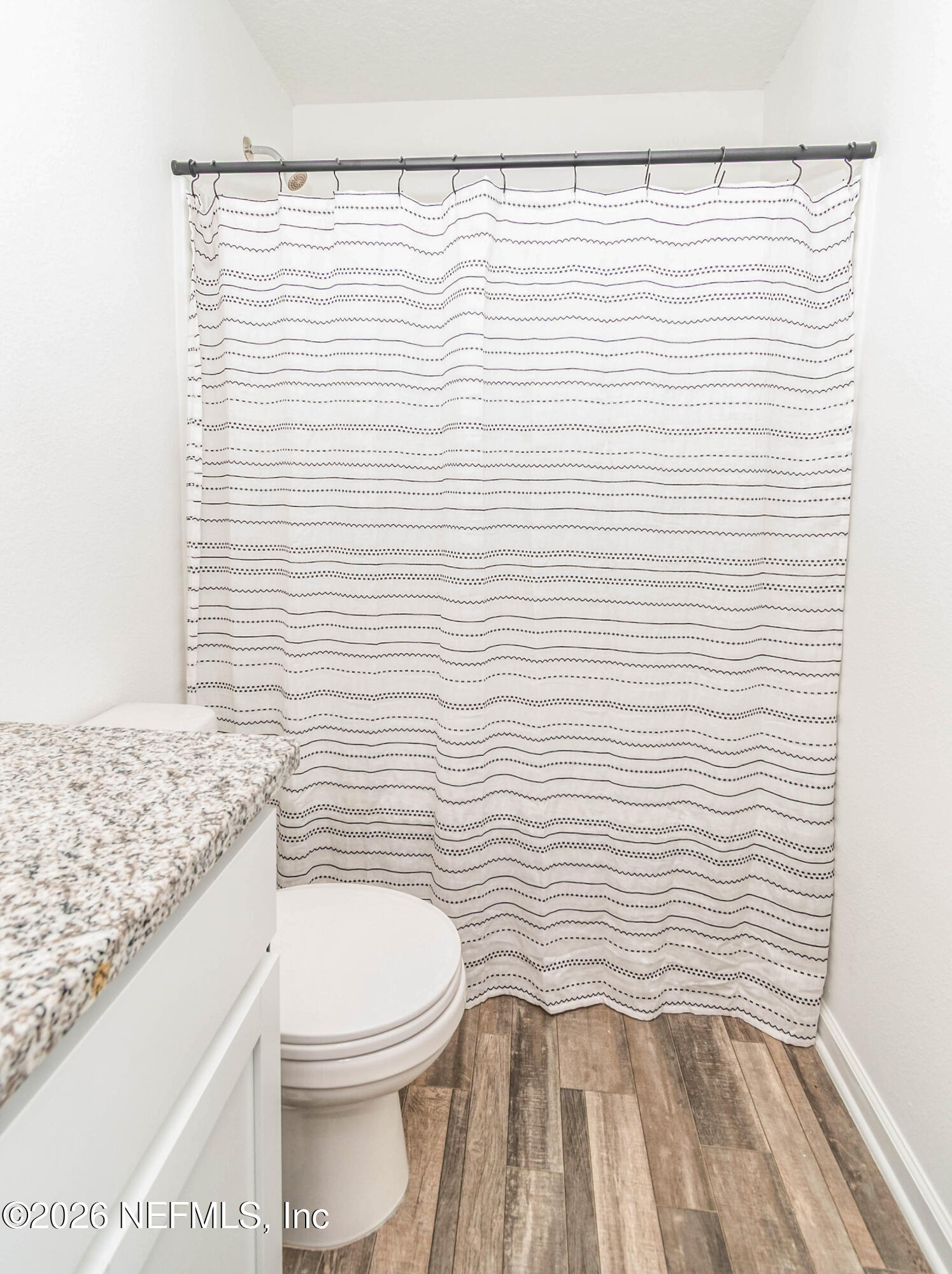 768 Constitution Place Macclenny, FL 32063 - Photo 28 of 41 a bathroom with a white toilet and a shower curtain