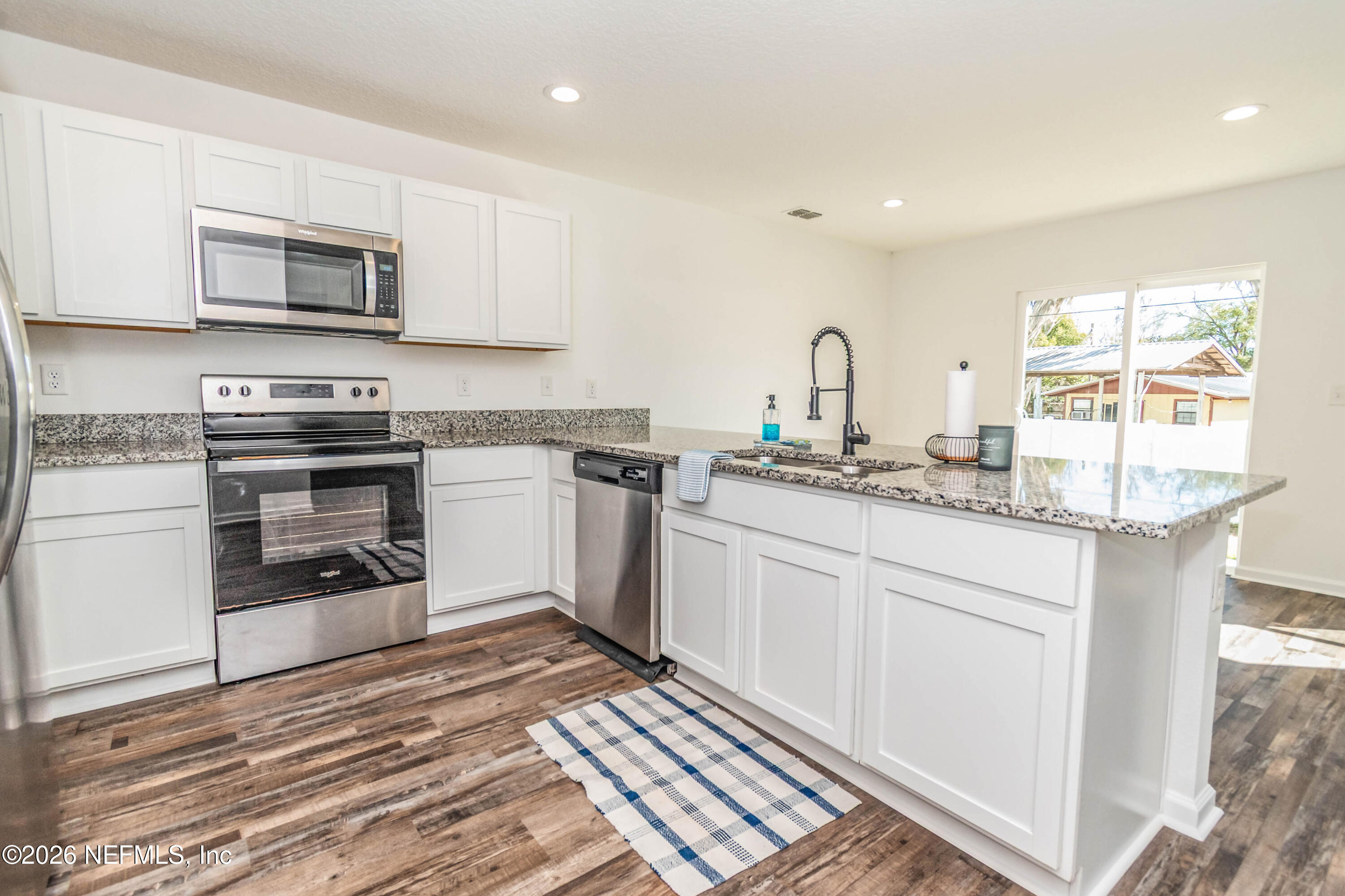 768 Constitution Place Macclenny, FL 32063 - Photo 6 of 41 a kitchen with stainless steel appliances granite countertop a stove a sink and a microwave