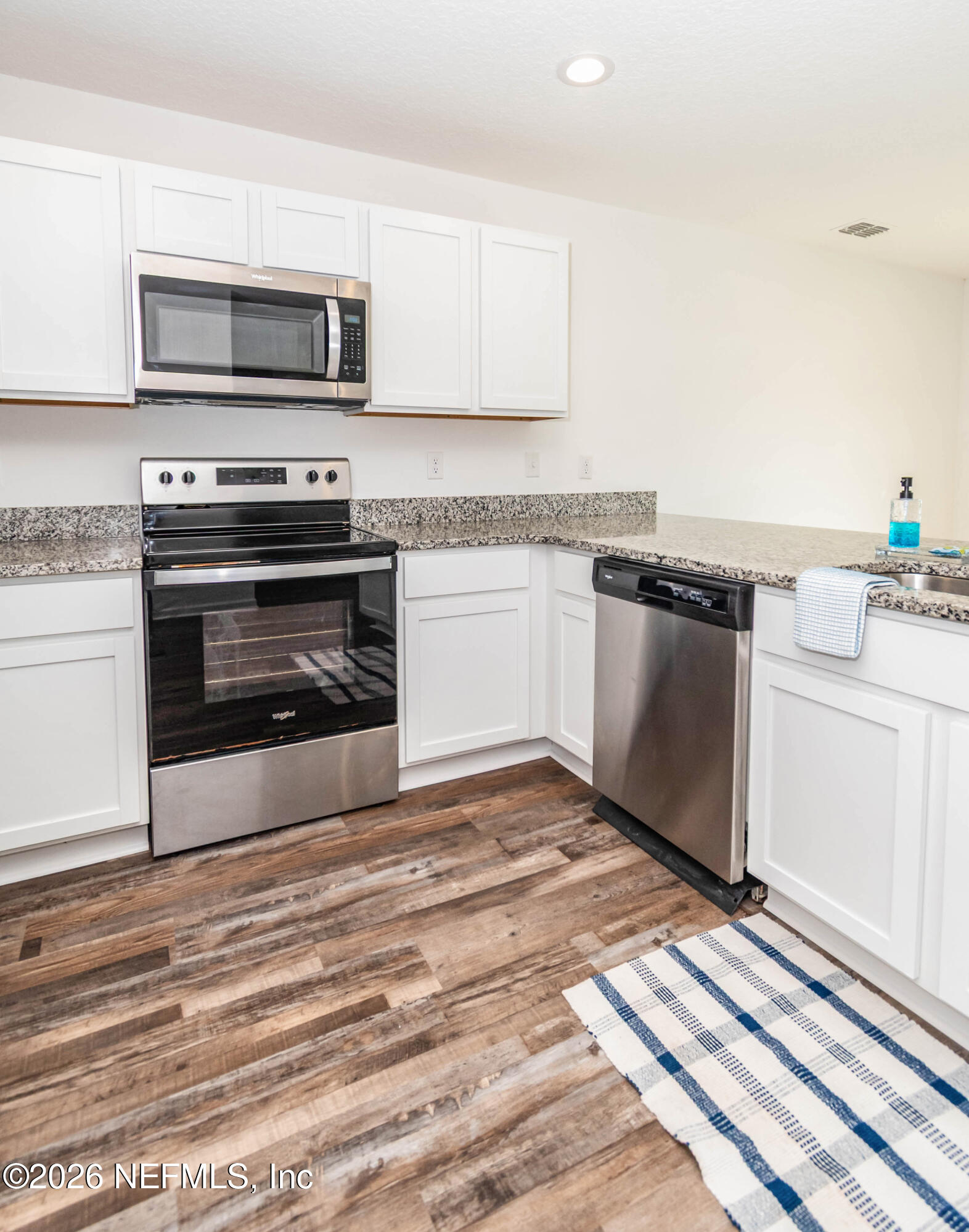 768 Constitution Place Macclenny, FL 32063 - Photo 10 of 41 a kitchen with granite countertop a stove top oven and cabinets