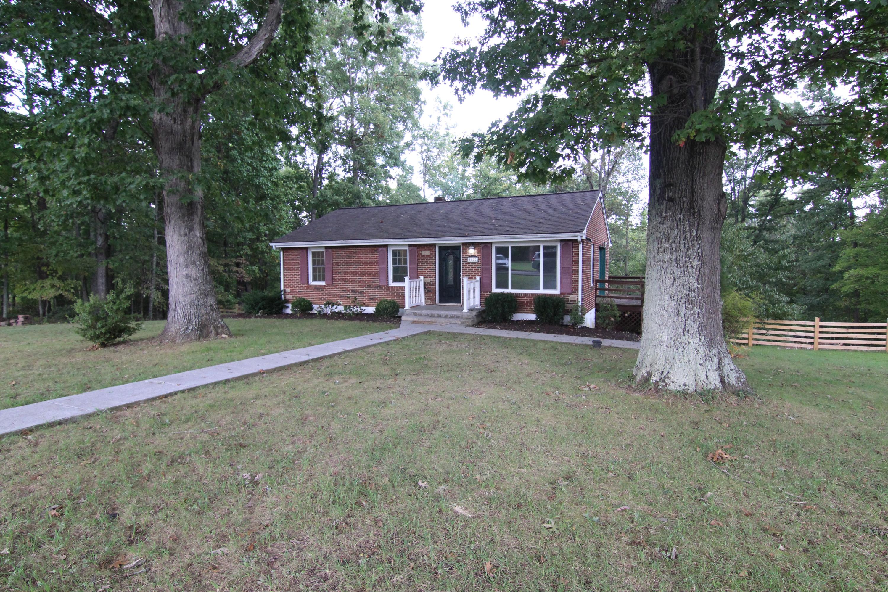 front view of a house with a tree and a yard