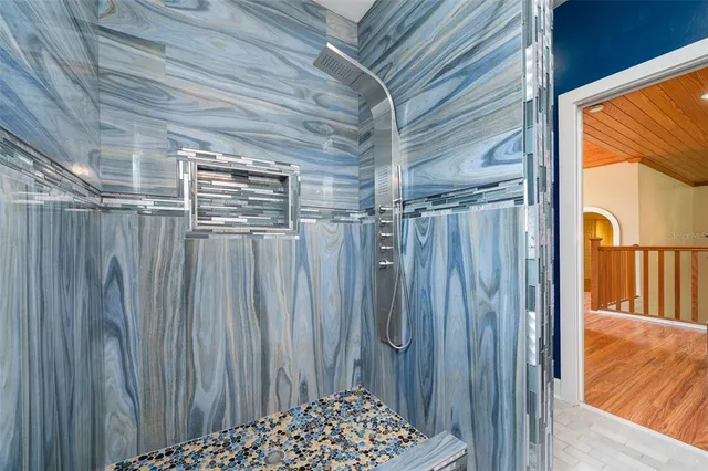 a kitchen with stainless steel appliances granite countertop a refrigerator a stove a sink and dishwasher with wooden floor