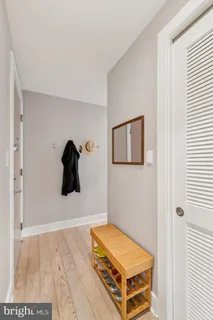 a living room with a baby bed and a painting on the wall