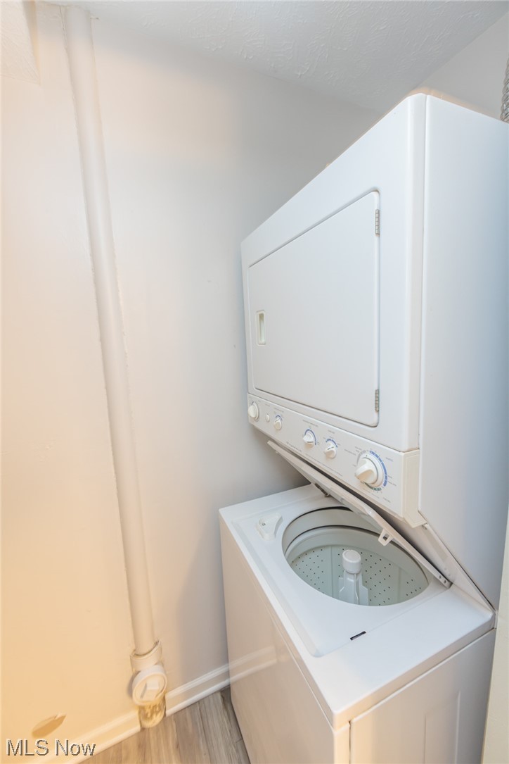 603 Literary Road Cleveland, OH 44113 - Photo 30 of 35 Laundry area featuring stacked washer / drying machine and light hardwood floors