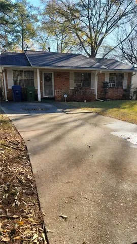 a front view of a house with a yard and potted plants
