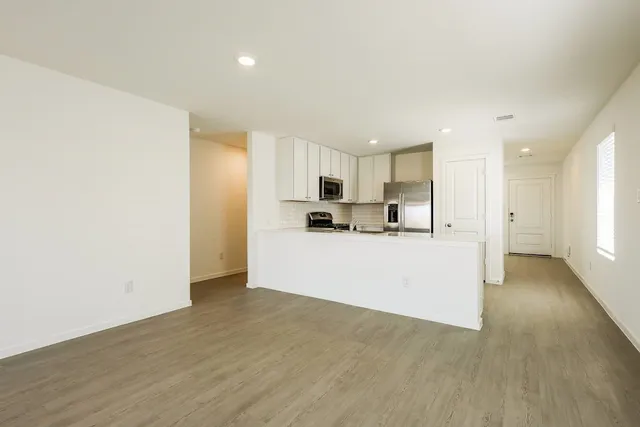 a view of a kitchen with wooden floor and windows