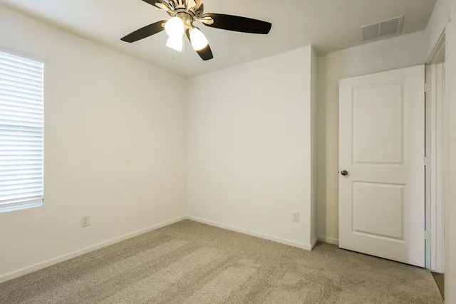 an empty room with closet and a chandelier fan