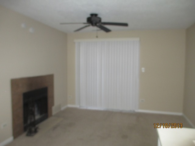 1901 North Hicks Road, Unit 103 Palatine, IL 60074 - Photo 2 of 7 a view of an empty room with a ceiling fan and a window