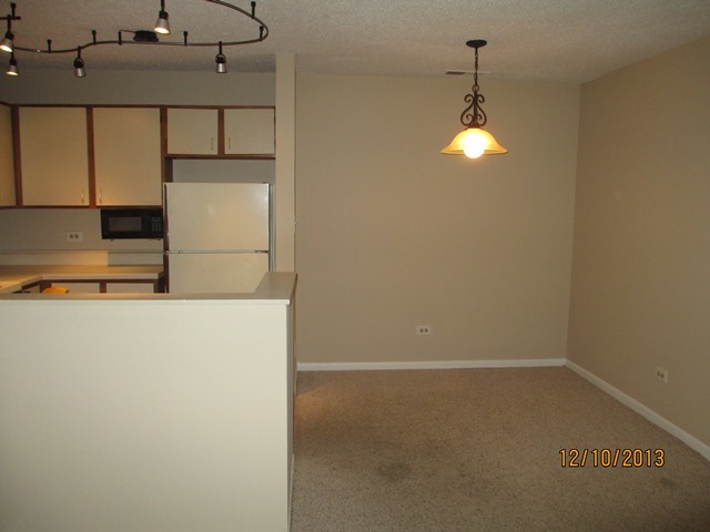 1901 North Hicks Road, Unit 103 Palatine, IL 60074 - Photo 3 of 7 a view of a refrigerator in kitchen and an empty room