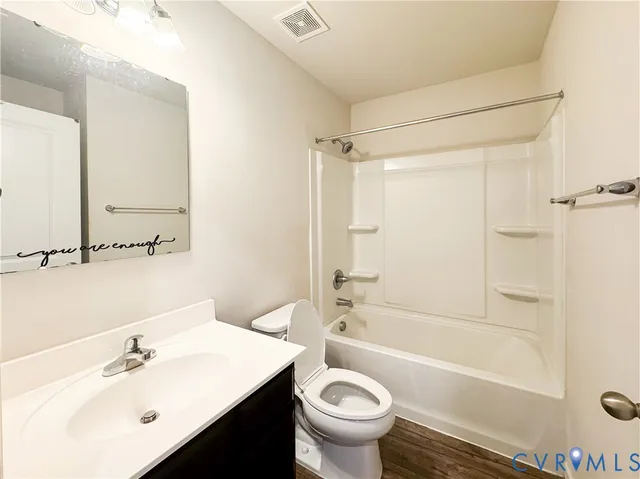 a view of a bedroom with wooden floor and a bathroom