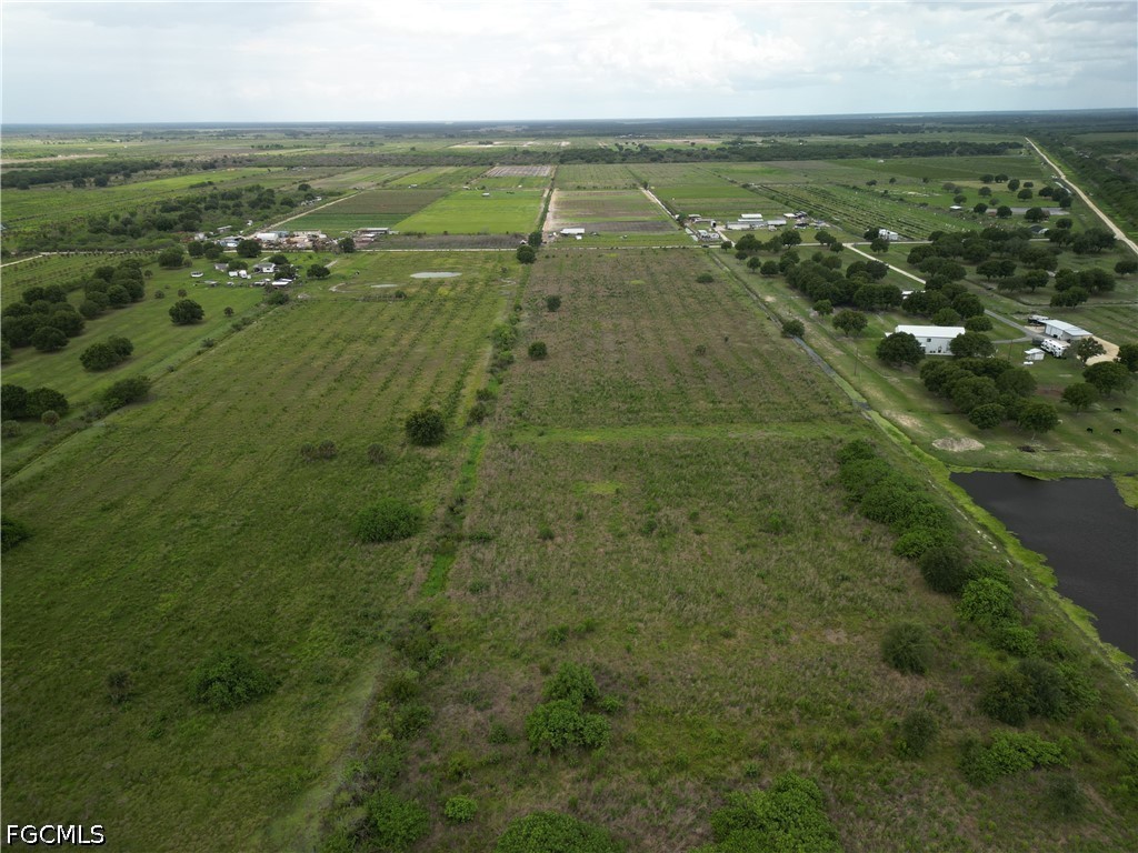 an aerial view of residential houses with outdoor space and trees
