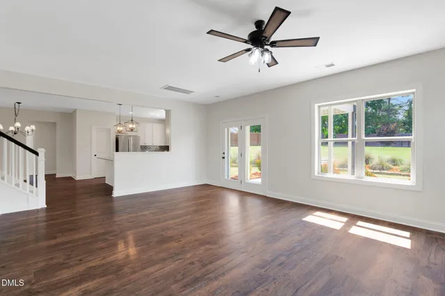 a view of a livingroom with wooden floor and a ceiling fan