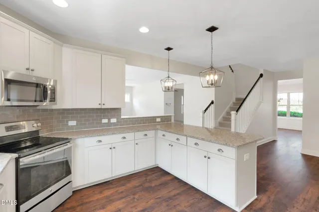 a kitchen with granite countertop a sink a stove and a wooden floors