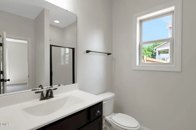 a bathroom with a sink toilet vanity and mirror