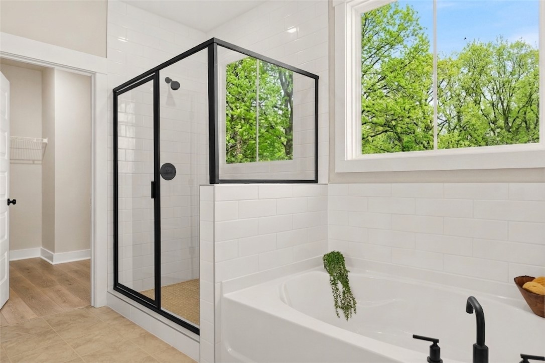 334 Summerall Drive Anderson, SC 29621 - Photo 4 of 28 This bright bathroom features a spacious soaking tub and a walk-in shower with natural views.