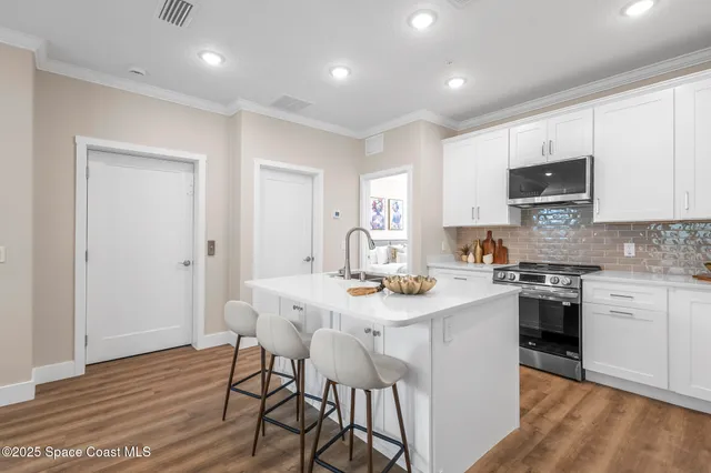a kitchen with a sink cabinets and wooden floor